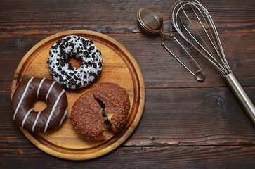 chocolate donuts on a wooden board, flat lay