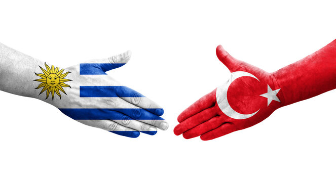 Handshake between Turkey and Uruguay flags painted on hands, isolated transparent image.