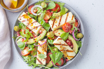 Salad with fried Halloumi cheese, cherry tomatoes, arugula and pomegranate seeds. healthy food.