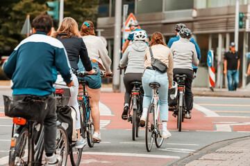 Fototapeta na wymiar Many Cyclists cross the street and the road at the intersection at the traffic light signal. Road rules safety concept