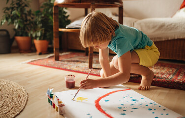 Child paints a picture at home