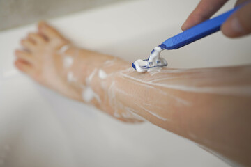 Shave with a razor. Shaving legs with a disposable razor in the shower. Removal of unwanted hair....