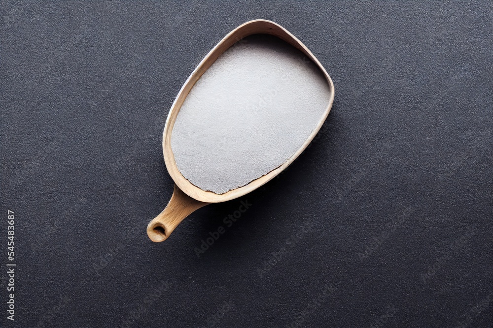 Poster a wooden spoon with a white handle on a black surface with a white background and a black background