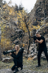 Fototapeta premium Guy and girl in military with bazooka and machine guns pose for camera