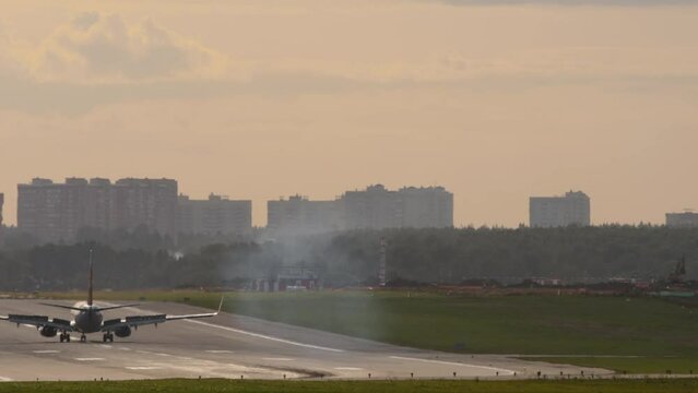 Passenger jet airplane braking after landing, rear view. Flaps up deceleration of the aircraft. Haze on the airport runway. Tourism and travel concept