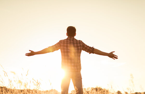 Young Man With Hands Up The Morning Sun Light Finding Happiness, Peace And Hope In Nature	