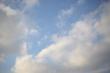 rays of the sun through cirrus clouds against a blue sky, white rainy clouds against a blue sky illuminated by the rays of the sun