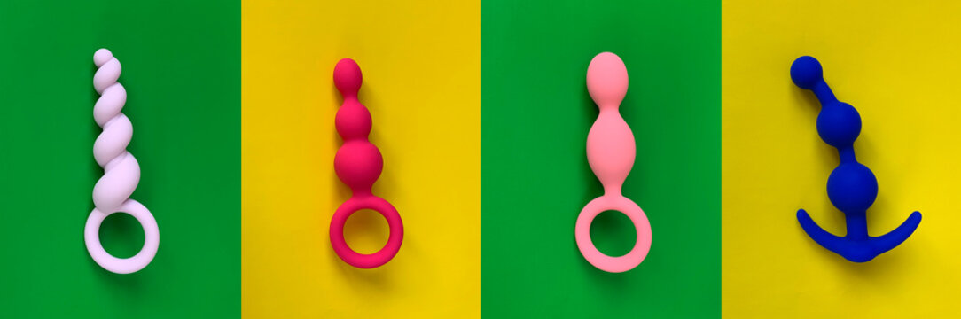 Anal toys. Butt plugs on green and yellow background. Sex toys