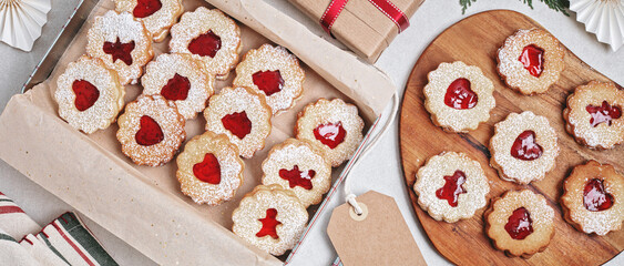 Traditional Linzer or sandwich cookies filled with raspberry jam packed in gift boxes. Xmas handmade gift packages, small business, home baking idea