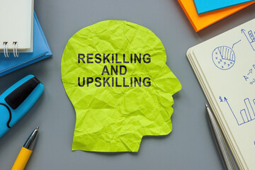 A paper head with inscription Reskilling and upskilling.