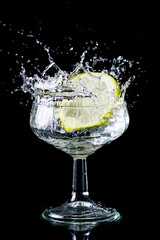 A slice of lemon making a splash in a glass of alcohol