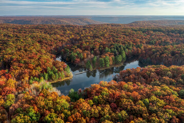 Secluded mountain top lake and fishing piers, aerial drone view with peak autumn colorful forest in Southern Middle Tennessee.