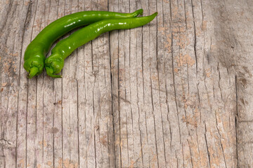 long green peppers on an old wooden background