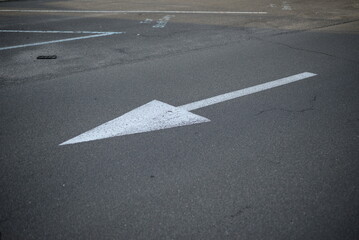 white arrow straight ahead direction of movement, direction of movement to the right, direction arrow for parking, white arrow on gray asphalt, asphalt texture, pedestrian crossing symmetrical