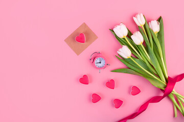 Bouquet of white tulips, hearts, envelope and a clock on an isolated pastel pink background. Time for love, decoration for women's day, mother's day, anniversary. Flatlay. Romantic date concept