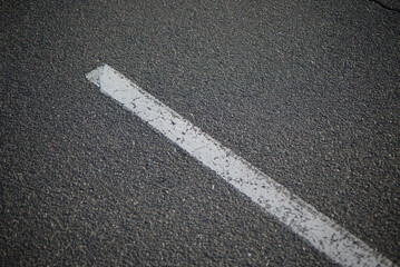 
background road markings white stripes on the asphalt road, parking spaces separated by white lines, symmetrical abstract lines on gray asphalt