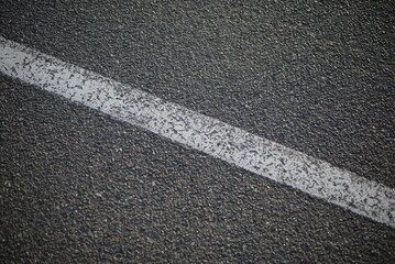 Fototapeta premium background road markings white stripes on the asphalt road, parking spaces separated by white lines, symmetrical abstract lines on gray asphalt