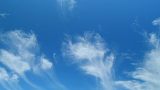 Flowing white cirrus clouds. Day weather, wind background. Beautiful blue sky in a sunny day. Time lapse.