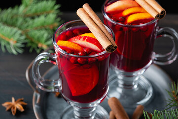 Two glasses with hot mulled wine with orange and spices on a wooden background. Hot drinks of winter and autumn. Autumn or winter still life