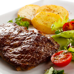 Grilled beefsteak, baked potatoes and vegetables