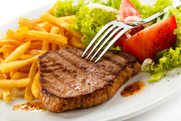 Grilled steak, French fries and vegetables