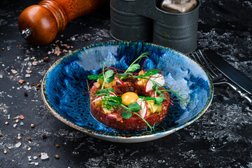 Beef steak tartare with raw egg yolk. French cuisine.