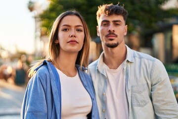 Obraz premium Young man and woman couple hugging each other standing with relaxed expression at street