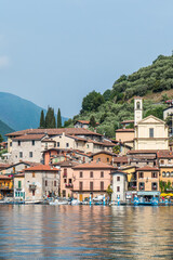 Fototapeta na wymiar Landscape of the lakeside of Peshiera Maraglio in Monte Isola with beautiful colored houses reflecting in the water