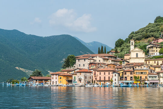 Landscape of the lakeside of Peshiera Maraglio in Monte Isola with beautiful colored houses reflecting in the water