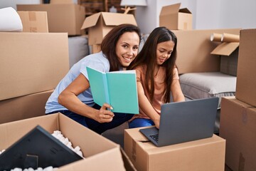 Woman and girl mother and daughter studying at new home