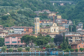 Panorama of the lakeside of Sulzano with colored houses that reflecting in the Lake Iseo