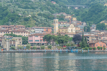 Fototapeta na wymiar Panorama of the lakeside of Sulzano with colored houses that reflecting in the Lake Iseo