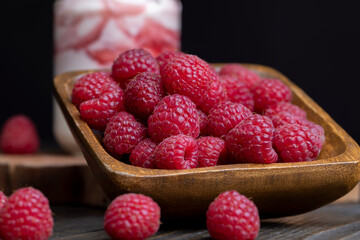 The harvest of red ripe raspberries is on the board