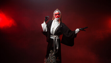 A young woman in fantastic makeup and an Asian kimono, the image of a cyber geisha. photo on a dark...