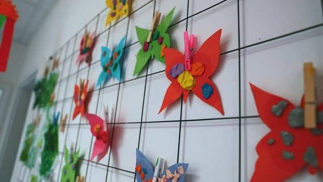 closeup view of a was full of paper-made colorful butterflies, kids' handcrafts at nursery, creative activities. High quality 4k footage