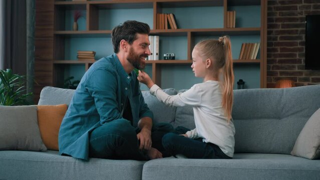 Happy child girl teen kid playing with loved dad father playful toddler preschool baby touch single daddy face family rest together on sofa at home caring relationship parental care positive childhood
