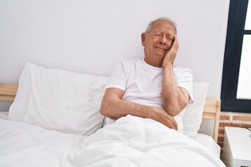 Senior grey-haired man  at bedroom