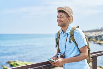 African american man tourist smiling confident using smartphone at seaside