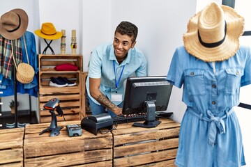 Young hispanic man working as shop assistant at retail shop