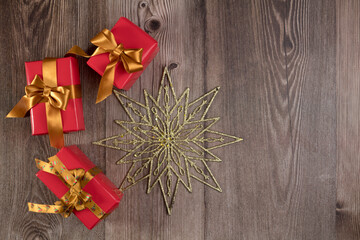 Christmas decoration and three gifts on wooden table