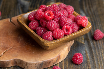 The harvest of red ripe raspberries is on the board
