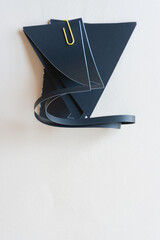 folded black paper stencil and yellow paper clip