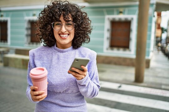 Young middle east woman smiling confident using smartphone at street