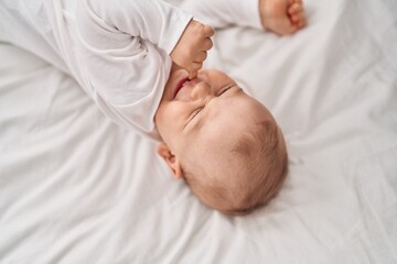 Adorable toddler lying on bed at bedroom