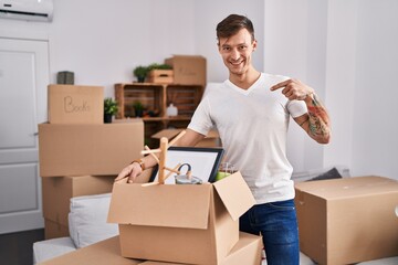 Caucasian man holding screwdriver at new home pointing finger to one self smiling happy and proud