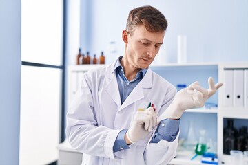 Young man scientist wearing gloves at laboratory