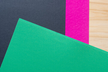 green black and pink paper on wood
