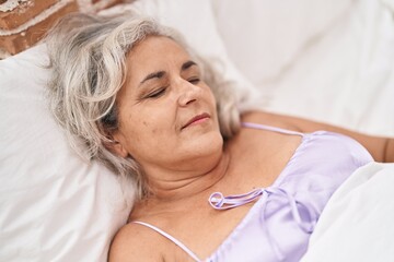 Middle age grey-haired woman lying on bed sleeping at bedroom
