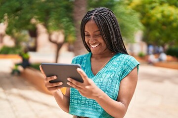 African american woman smiling confident watching video on touchpad at park