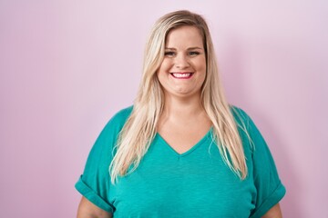 Caucasian plus size woman standing over pink background with a happy and cool smile on face. lucky...